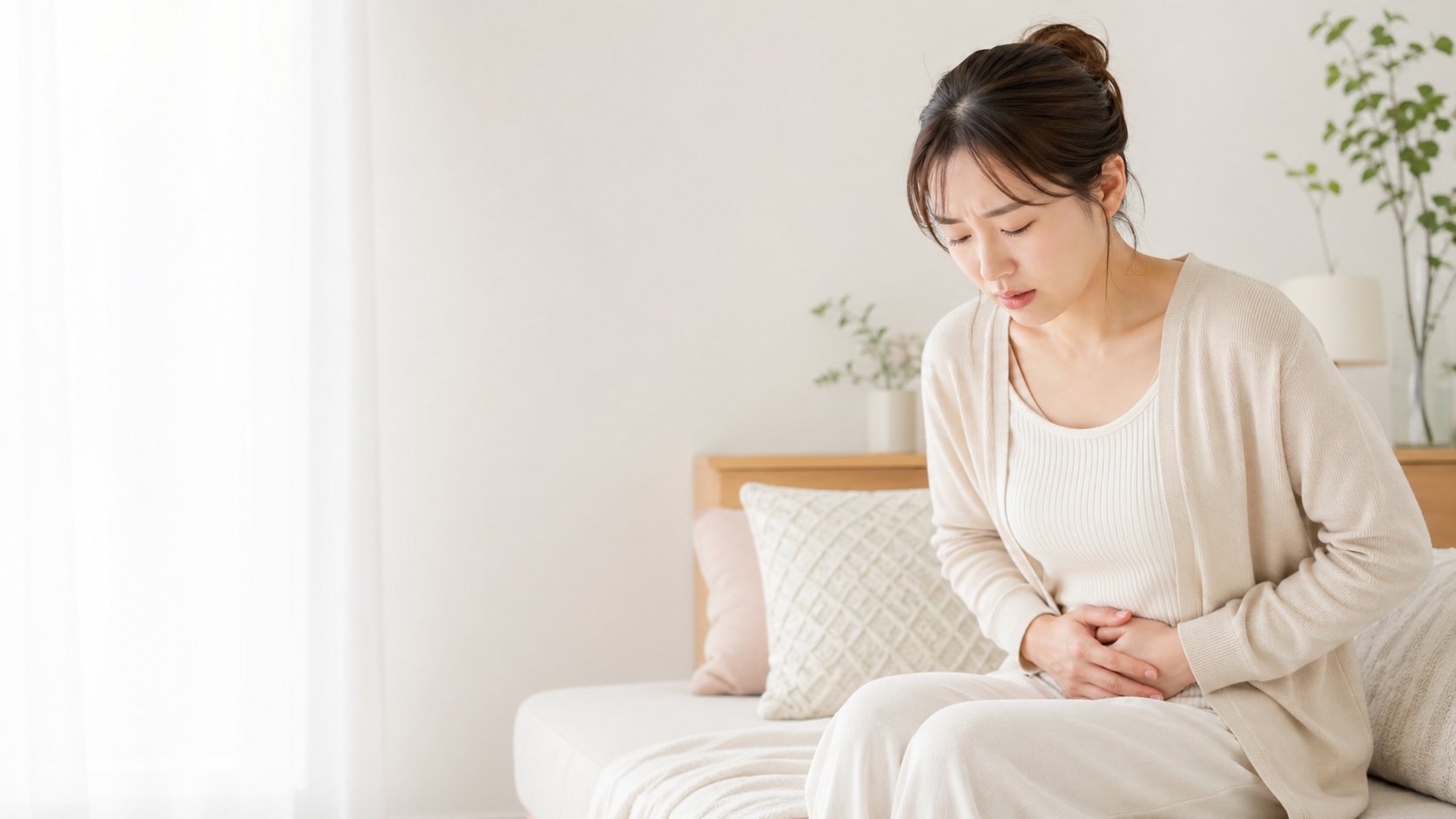 生理痛で下腹部に手を当てる女性のイメージ - 今西健はり・灸院(大阪府八尾市)